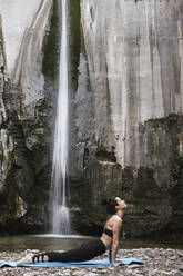 Frau übt Yoga am Wasserfall, Kobra-Pose - LJF00372
