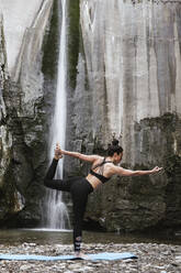 Frau übt Yoga am Wasserfall - LJF00373