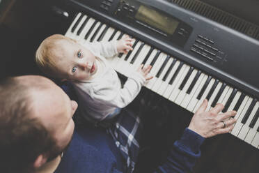Vater spielt Keybord mit seiner kleinen Tochter, Draufsicht - IHF00168