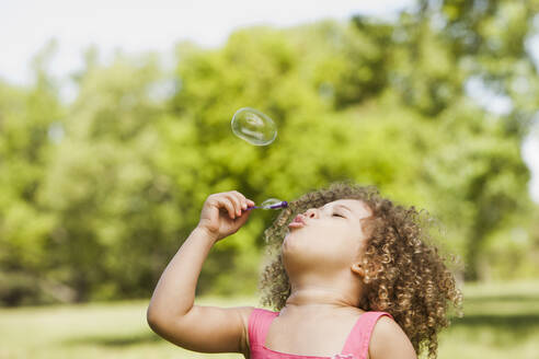 Mixed race girl blowing bubbles - BLEF08789