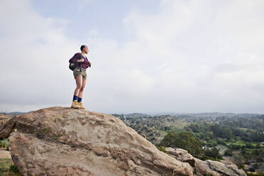 Black hiker standing on rock in remote area - BLEF08833