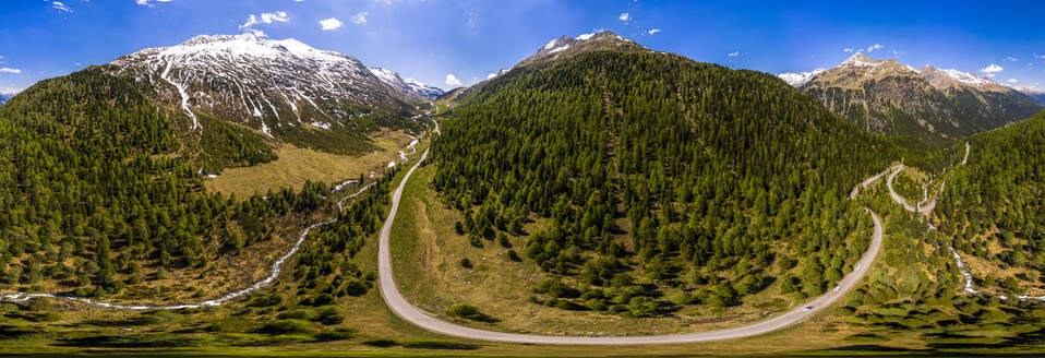 Panoramablick auf eine kurvenreiche Straße durch die bewaldete Landschaft des Defereggentals, Osttirol, Österreich - STSF02081