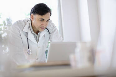 Mixed race doctor working on laptop - BLEF08844