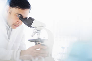 Mixed race scientist using microscope - BLEF08846