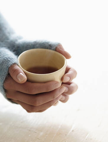 Hispanic woman holding cup of tea stock photo