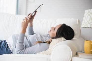 Schwangere kaukasische Frau mit digitalem Tablet auf dem Sofa - BLEF08922