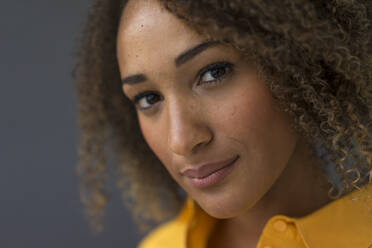 Porträt einer jungen Frau mit lockigem Haar - MOEF02322