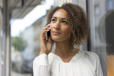 Porträt einer jungen Frau am Telefon - MOEF02343