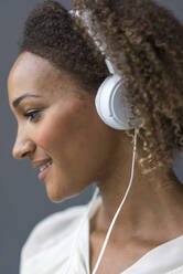 Profile of young woman with white headphones - MOEF02358