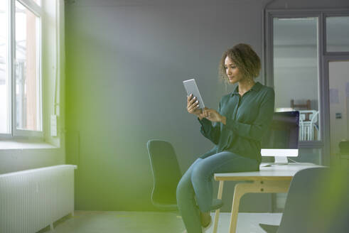 Junge Geschäftsfrau benutzt digitales Tablet im Büro - MOEF02368