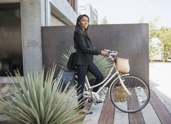 Woman standing with bicycle - BLEF08923