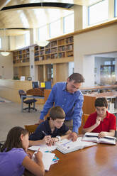 Lehrer im Gespräch mit Schülern in der Bibliothek - BLEF08941