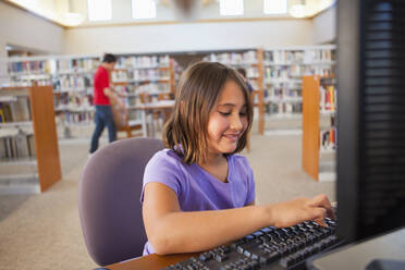 Mädchen benutzt Computer in der Bibliothek - BLEF08948