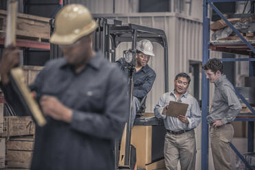 Arbeiter sprechen in einer Fabrik miteinander - BLEF08987