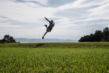 Kaukasischer Mann tanzt auf einem Feld - BLEF09064