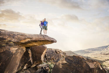 Caucasian couple on rock formation admiring landscape - BLEF09115