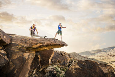 Caucasian couple stretching on rock formation - BLEF09116