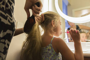 Caucasian mother brushing daughter's hair - BLEF09164