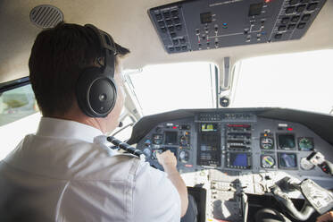 Kaukasischer Pilot bei der Arbeit im Cockpit eines Flugzeugs - BLEF09218