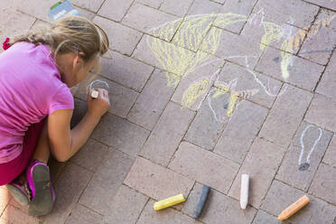 Caucasian girl drawing with chalk on brick - BLEF09250
