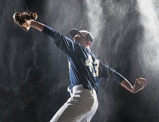 Kaukasischer Baseballspieler beim Werfen im Regen - BLEF09284