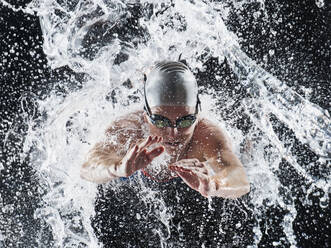 Caucasian swimmer splashing in water - BLEF09291