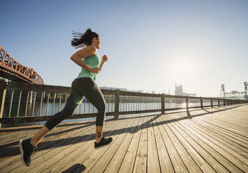 Caucasian woman jogging on urban waterfront - BLEF09294