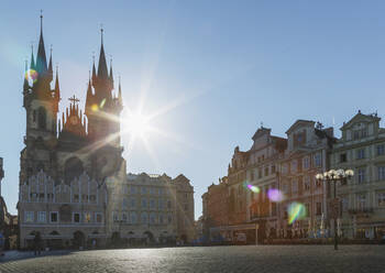 Sun shining behind ornate church in city square - BLEF09357