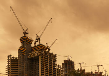 Low angle view of cranes constructing Doha highrise buildings, Doha, Qatar - BLEF09376