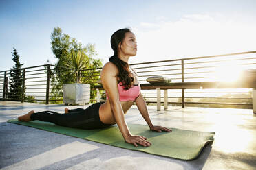 Chinesische Frau übt Yoga auf dem Balkon - BLEF09454