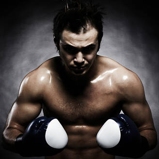 Kaukasischer Boxer, der seine Muskeln spielen lässt - BLEF09475