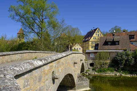 Alte Bogenbrücke über die Tauber mit Stadthäusern im Hintergrund, Rothenburg ob der Tauber, Bayern, Deutschland, lizenzfreies Stockfoto