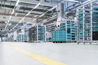 Stacked containers inside modern factory warehouse, Stuttgart, Germany - DIGF07181