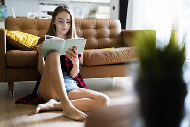 Young woman with a photo album at home - GIOF06678