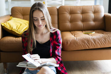 Young woman with a photo album at home - GIOF06680