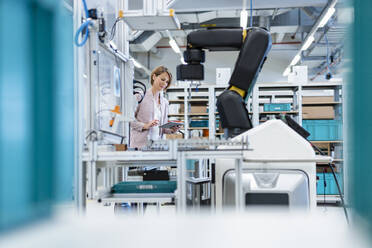 Businesswoman with tablet in a modern factory hall - DIGF07210