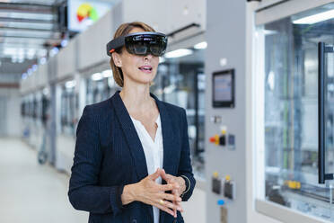 Geschäftsfrau mit AR-Brille in einer modernen Fabrik - DIGF07248