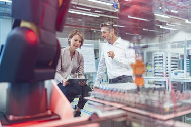 Businessman and businesswoman talking in a modern factory hall - DIGF07338