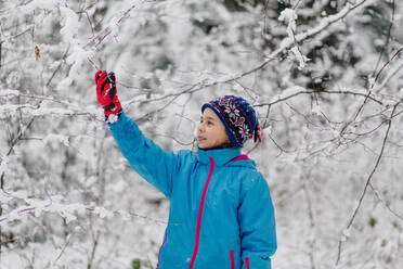 Girl standing in a wintry forest - OGF00021