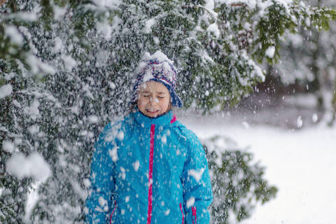 Girl standing in a wintry forest stock photo