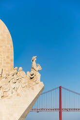 Portugal, Lissabon, Belem, Denkmal der Entdeckungen und Brücke 25 de Abril gegen klaren Himmel - WDF05293