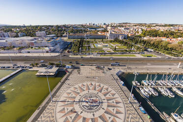 Portugal, Lisbon, Belem, High angle view of compass rose and map mosaic near marina, Jeronimos Monastery in background - WDF05314