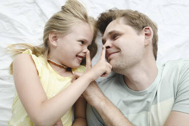 Russia, Sochi, Father and smiling daughter in the bedroom - EYAF00282