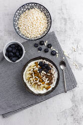 Bowl of fresh muesli, blueberries and puffed rice seen from above - GIOF06728