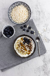 Schale mit frischem Müsli, Blaubeeren und Puffreis von oben gesehen - GIOF06728