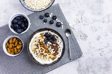 Bowl of fresh muesli, blueberries and almonds seen from above - GIOF06732