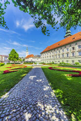 Österreich, Kärnten, Klagenfurt am Wörthersee, Garten und Heiliggeistkirche an einem sonnigen Tag - THAF02517