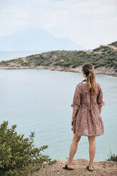 Griechenland, Rückansicht einer Frau mit Blick auf den Berg Athos über das Meer - BZF00493