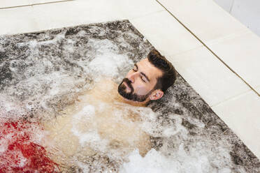 Man enjoying the whirlpool in a spa - LJF00394