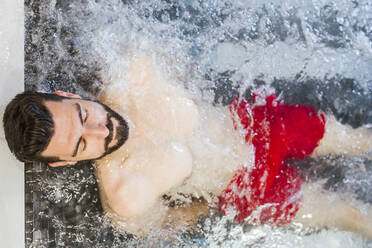 Man enjoying the whirpool in a spa - LJF00395